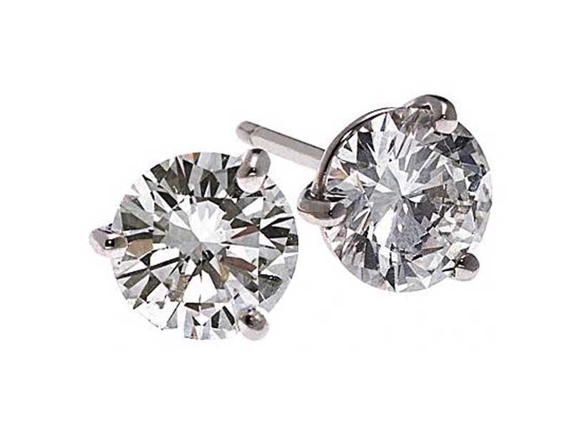 A pair of round diamond stud earrings set in a four-prong metal setting, displayed on a white background.