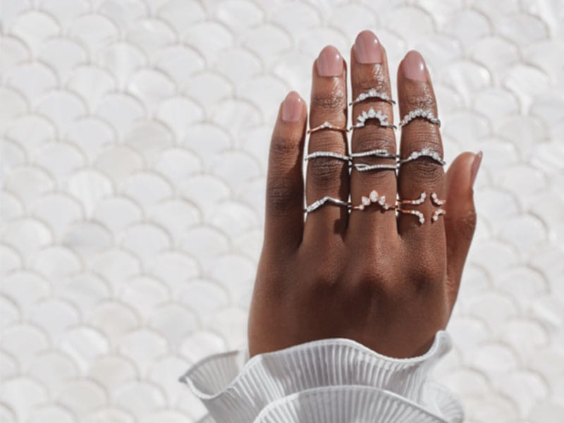 A woman's hand holding a stack of Engagement Ring Wraps.