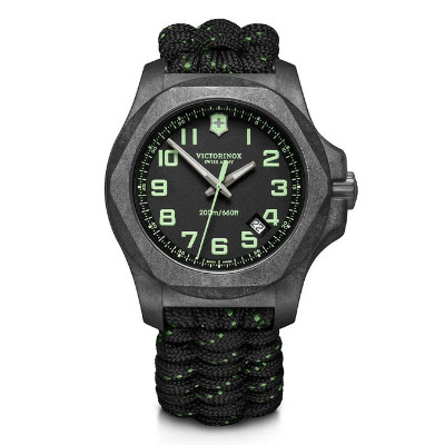 Victorinox wristwatch with black dial, green numerals, and a black and green woven paracord strap. The watch displays the date and has a rugged, tactical design.