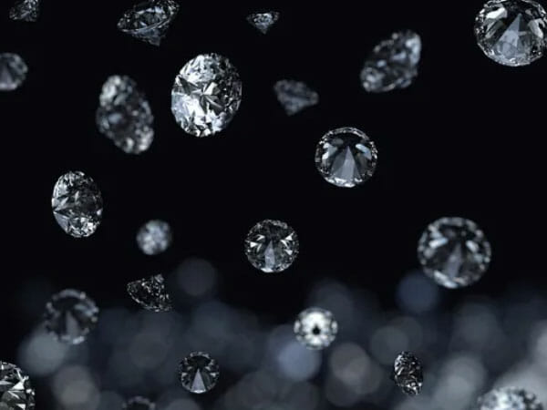 Multiple round-cut diamonds are suspended in midair against a dark blurred background, creating a floating effect.