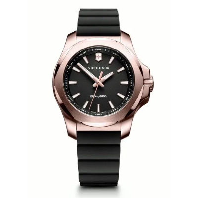 A Victorinox wristwatch with a black face, rose gold case, silver hour markers, and a black rubber strap, displayed against a white background.